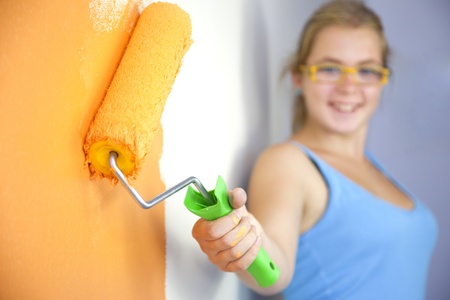 Happy young woman painting wall / Color your life / focus on the rollerの写真素材