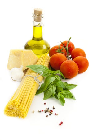 Ingredients for Italian cooking: olive oil, basil, tomato, parmesan, garlic and spaghetti /  isolated on whiteの写真素材