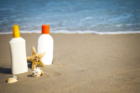 Suntan Lotion Flacons on the Beach with copy spaceの写真素材