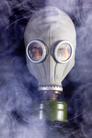 Man is in Gas Mask with Smoke around and Fire reflectionの写真素材