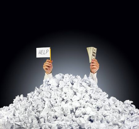 Help me! Person under crumpled pile of papers with hand holding a help sign and money の写真素材