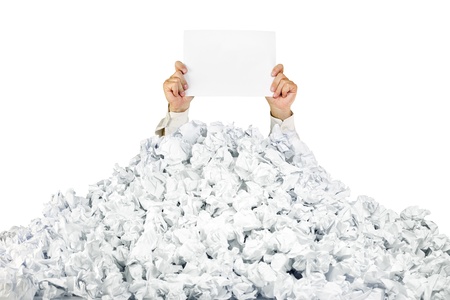 Person under crumpled pile of papers with hand holding a blank page / isolated on whiteの写真素材