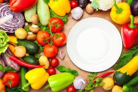 Fresh Organic Vegetables on wooden Table Around White Plate / with copy space for your textの写真素材