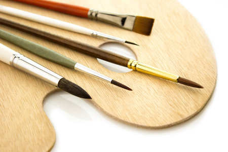 Five art brushes on wooden natural palette isolated on white backgroundの写真素材