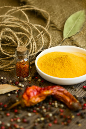 Natural turmeric in ceramic saucer with different spices and paprikaの写真素材