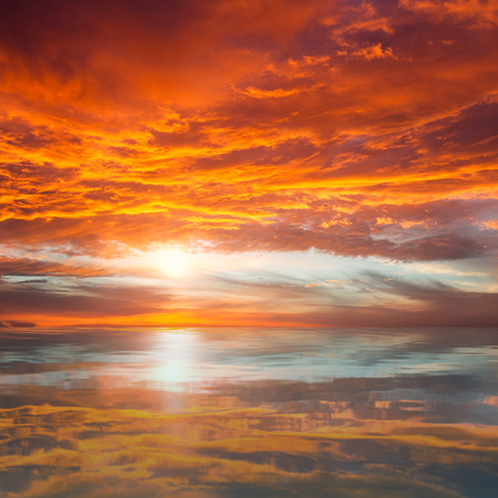 Reflection of Beautiful Sunset   Orange and Red Majestic Clouds above Waterの写真素材