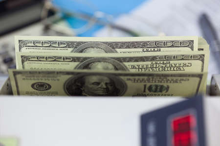 Hundred dollar banknots in the counting machine
