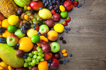 Mix of Fresh Fruits  with water drops on dark wooden table - copy spaceの写真素材