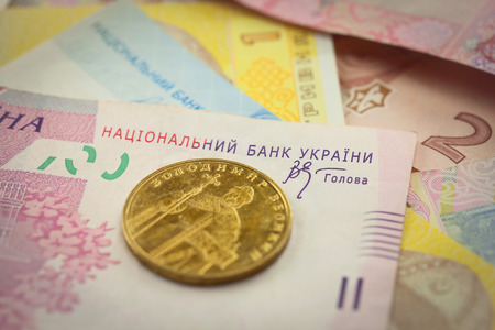 Bright ukrainian golden coin and banknots macro backgroundの写真素材