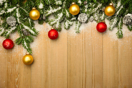 Christmas background with fresh firtree and  baubles on wood with bright snowの写真素材