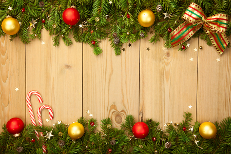 Christmas background with firtree, candies, baubles and stars on woodの写真素材