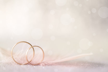 Two Golden Wedding Rings and  Feather - light soft background for marriageの写真素材