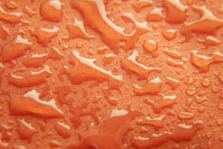 Orange waterproof membrane textile background with dropsの写真素材