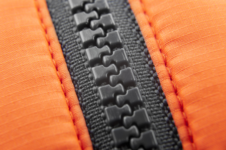 Macro black ziplock with orange canvas background \\ horizontalの写真素材