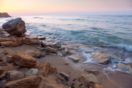 beautiful sunrise landscape,  the rocky sea coast and water wavesの写真素材