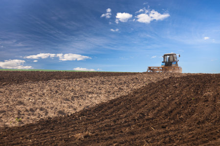 Agricultural Lanscape - Tractor working on the field - spring sunny dayの写真素材