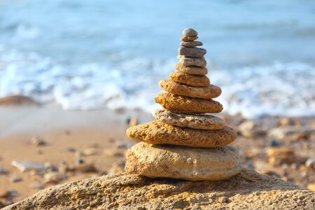 Stones balance and blue sea on defocused background with bokeh. Spa, freedom and stability concept on rocksの写真素材