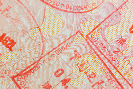 Different border stamps in a passport page - travel backgroundの写真素材