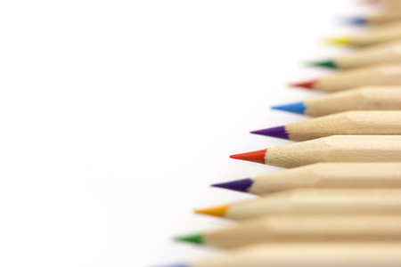 Diagonal row of wooden colorful pencils with bokeh isolated on whiteの写真素材