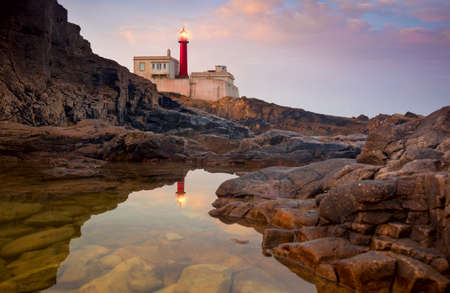 Lighthouse at  beautiful sunrise sky and its reflection is in the water, Portugal, Europeの写真素材