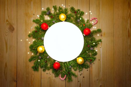 Christmas Round Frame with firtree, candies and baubles with stars on rustic wood, copy space for textの写真素材