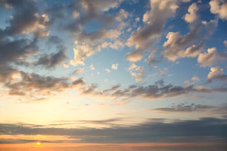 Gentle Sundown Sky with Sun and  Colorful Clouds, natural background for wallpaperの写真素材