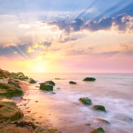 Sunrise landscape over beautiful rocky coastline in the Ocean with sunbeamsの写真素材