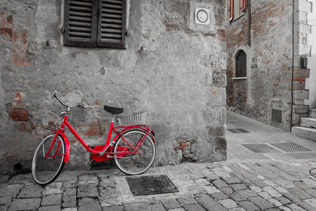 Old Mediterranean town street with red retro bike and sunlight - vintage toned, Italy, Europeの写真素材