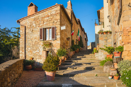 Small Old Mediterranean town - narrow street in Pienza with sunlight and flowers, Tuscany,  Italy, Europeの写真素材