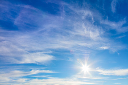 Sunny background of blue sky with real sun and light clouds, good day, warm weather. Big sizeの写真素材