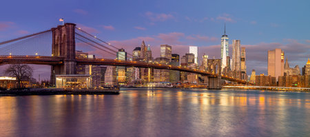 Panorama of Brooklyn Bridge and Manhattan skyscrapers at sunrise time, beautiful  gentle colors of sky and city illuminations, New York, USA - Big sizeの写真素材