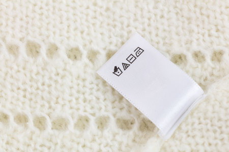 Laundry tag on white knitted wool sweater background, big sizeの写真素材
