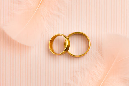 Delicate Light Wedding background with gold rings and Angels feathers, luxury styleの写真素材
