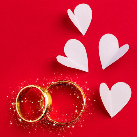Wedding background - two gold wedding rings with sparkle and handmade hearts design, celebration cardの写真素材