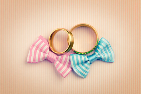Vintage style Wedding card background - two gold wedding rings and two bowknots, retro tonedの写真素材