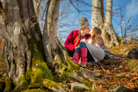 Young happy couple, kisses and love,  local traditional clothes and sunny day in natural forest, european man and womanの写真素材