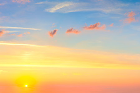 Natural sunrise sundown sky with sun and colorful clouds background without birdsの写真素材