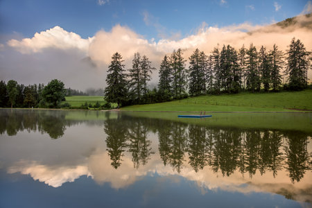 Foggy Morning on lake, with beautiful clouds and reflection, Freizeitsee Zenz, Austria, Europeの写真素材