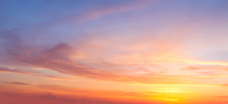 Real majestic sunrise sundown sky background with gentle colorful clouds without birds. Panoramic, big sizeの写真素材