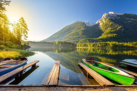 Early morning near the lake with boats and mountains. Beautiful sunny holiday - recreation, landscapeの写真素材