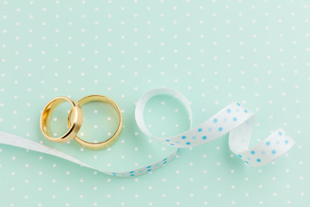 Wedding  Background  - Two Wedding gold rings and ribbons on light-green background, retroの写真素材