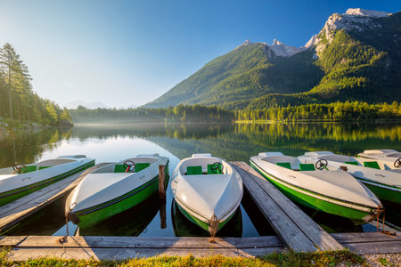 Landscape of Early morning near the lake with boats and mountains. Beautiful sunny holiday. Germanyの写真素材