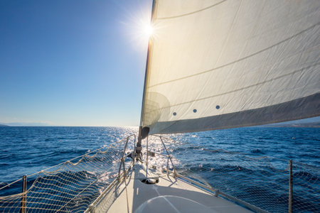 Sailing at calm weather. A view from the yacht's deck to the bow and sails. Sail boat with set up sails gliding in open sea. Greece, Europeの写真素材