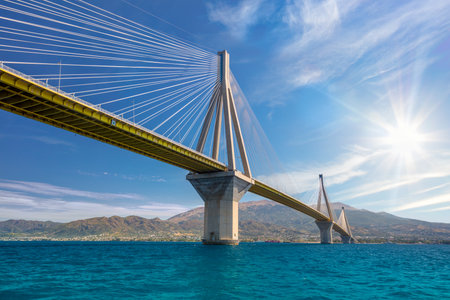 Amazing Modern Bridge against blue sky with sun. Rion-Antirion Bridge. The bridge connecting the cities of Patras and Antirrio, Greeceの写真素材