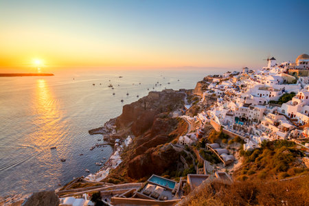 Sunset sun view of traditional Greek village Oia on Santorini island in Greece. Santorini is iconic travel destination in Greece, famous of its sunsets and traditional white architectureの写真素材