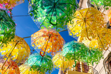 Street decorated with umbrellas of different colors in old town on summer sunny day, Aegina island, Greece, Europeの写真素材