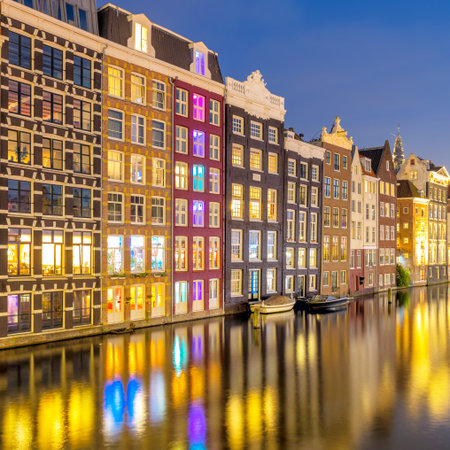 Famous old houses of Amsterdam. The houses stand in the water and have a beautiful reflection. Touristic district Damrak. These houses are famous all over the world. Amsterdam, Holland, Europeの写真素材