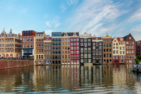 Famous houses of Amsterdam. The houses stand in the water and have a beautiful reflection. Touristic district Damrak. These houses are famous all over the world. Amsterdam, Holland, Europeの写真素材