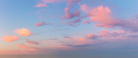 Pastel Light pink clouds in the blue sky during dawn sunset, sundown backgroung, panoramicの写真素材