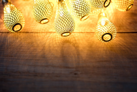 Holiday banner background - lit garland lights create a festive mood. Festive background on wood with copy space for textの写真素材
